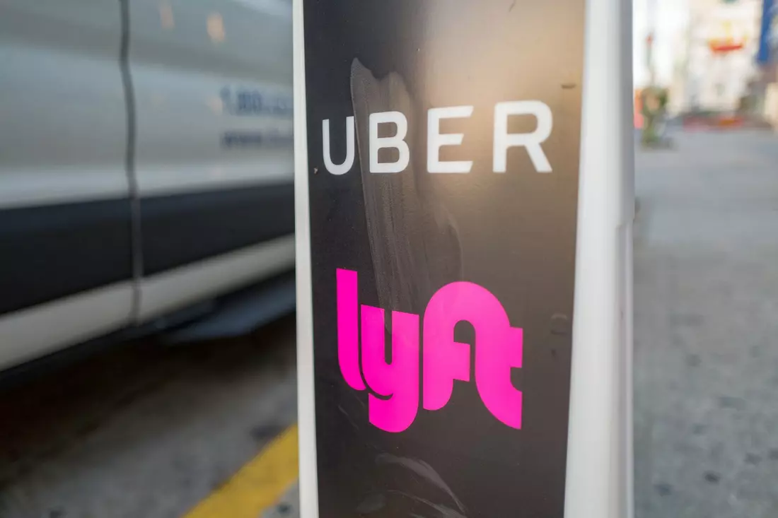Услуги такси Uber и Lyft на городских улицах — American Butler Логотипы Uber и Lyft на городском знаке