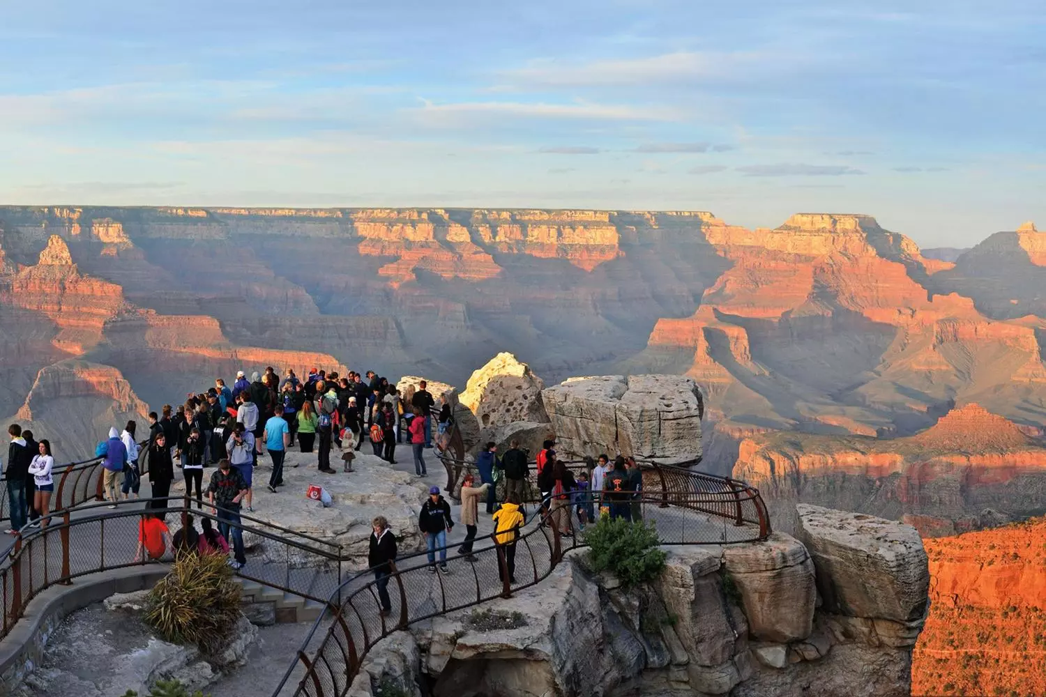 Grand Canyon Majesty: A View That Steals Your Breath Panoramic view from Grand Canyon overlook showing layered red rock formations and deep valleys under a clear blue sky