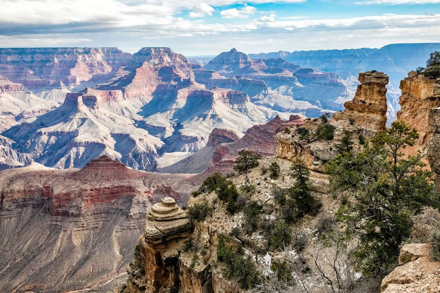 Grand Canyon's Magnificent Vistas: Nature's Masterpiece Unveiled Stunning panoramic view of Grand Canyon's colorful rock layers, deep valleys and winding Colorado River under dramatic cloud-filled sky