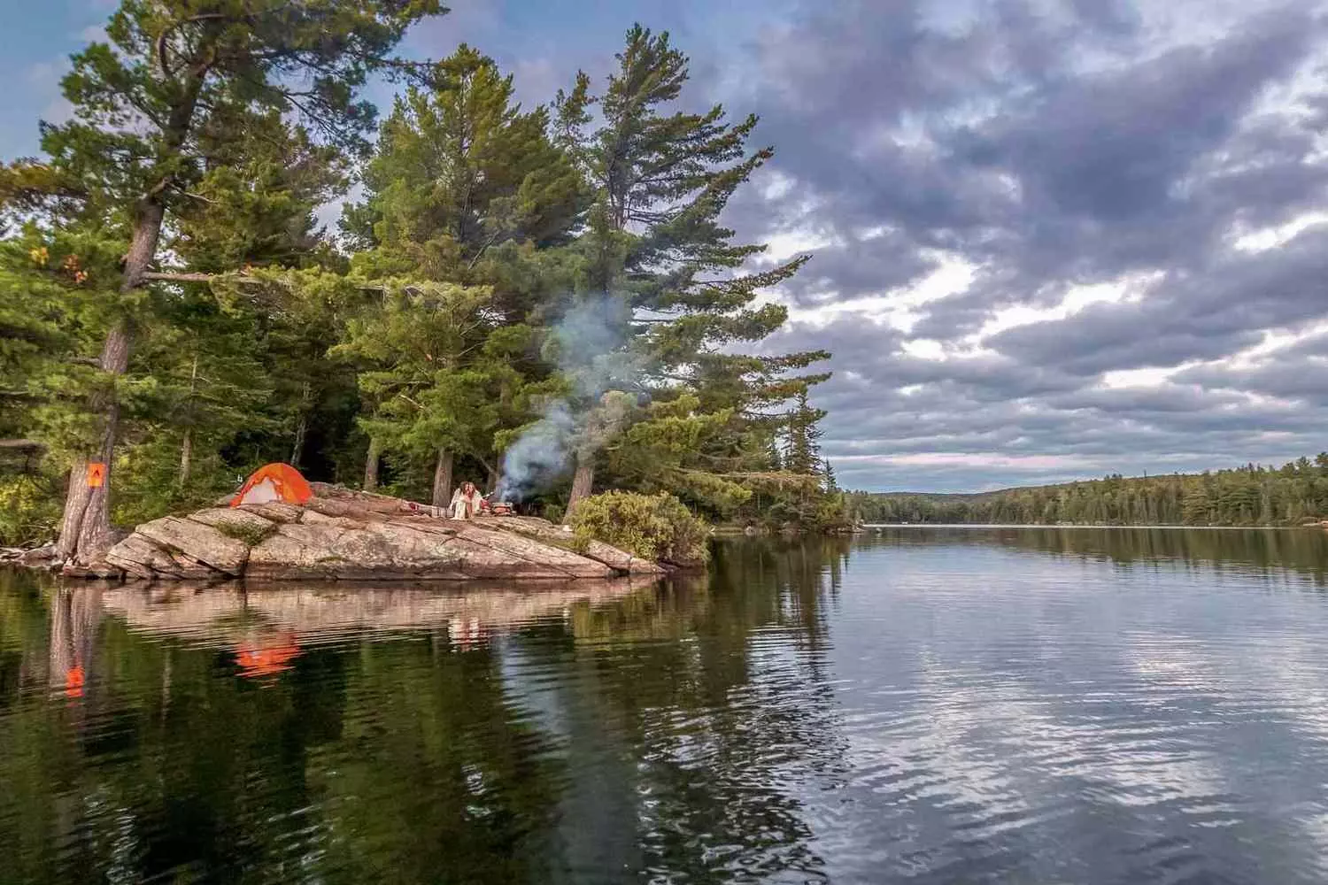 Great Lakes Camping: Where Shoreline Dreams Meet Starry Nights A cozy tent set up on a sandy Lake Michigan beach at sunset, with a crackling campfire nearby and gentle waves lapping the shore under a colorful sky