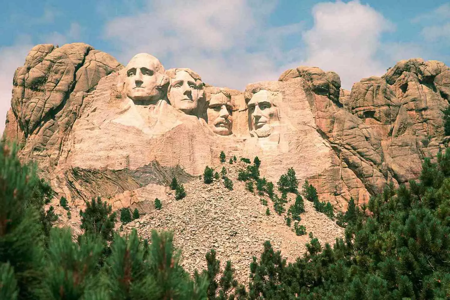 Mount Rushmore National Memorial — America’s Iconic Landmark The massive granite faces of U.S. presidents Washington, Jefferson, Roosevelt, and Lincoln carved into Mount Rushmore under a clear blue sky