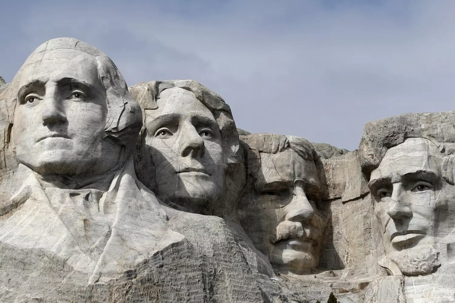 Mount Rushmore National Memorial — America’s Iconic Landmark The massive granite faces of U.S. presidents Washington, Jefferson, Roosevelt, and Lincoln carved into Mount Rushmore under a clear blue sky