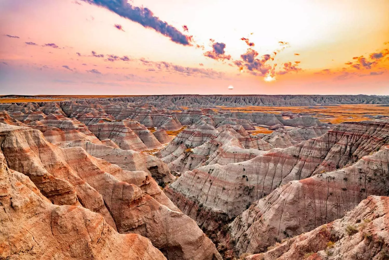 Badlands National Park: South Dakota's Surreal Desert Landscape Colorful layered rock formations and eroded buttes in Badlands National Park under dramatic sunset lighting
