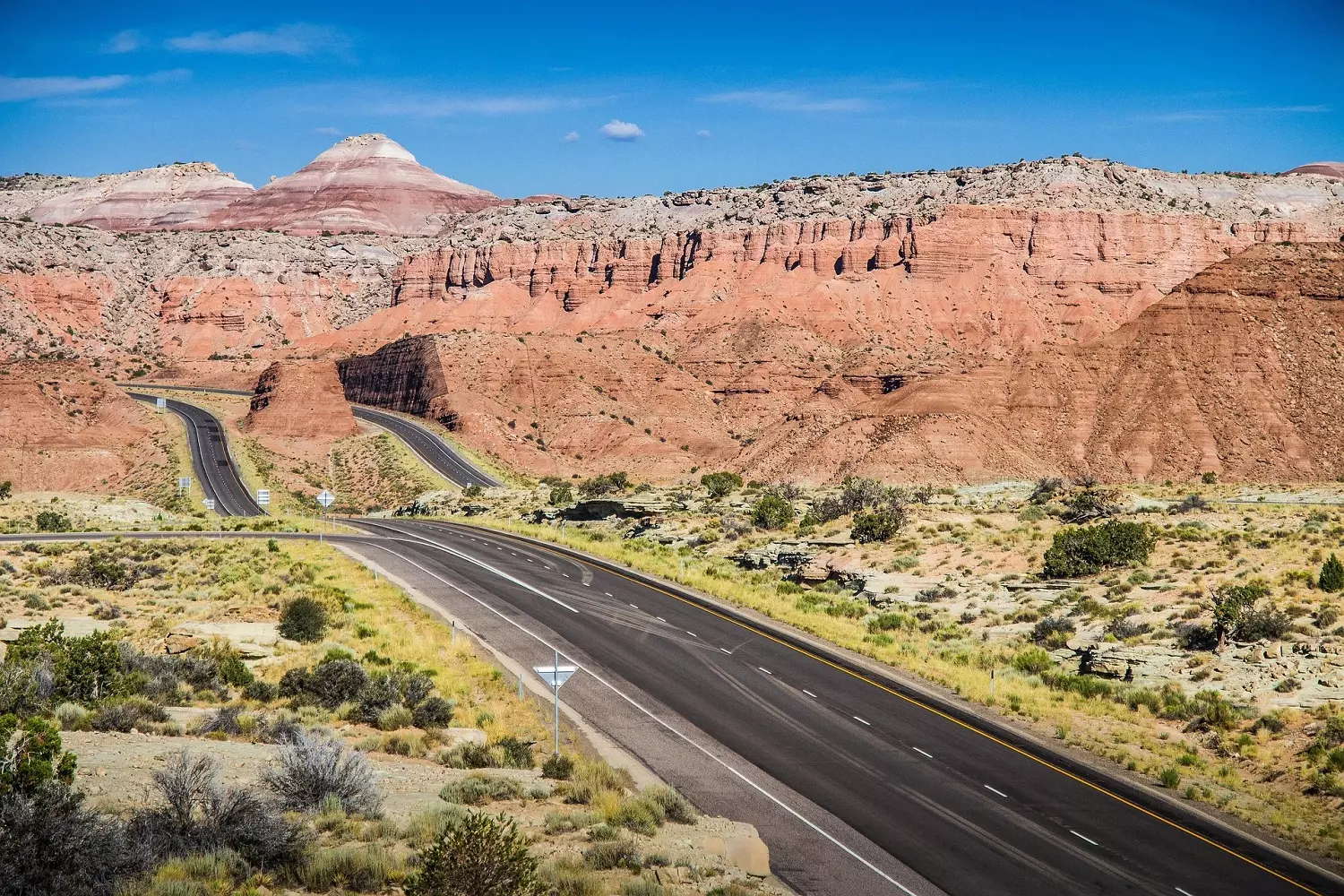 A common type of landscape in the southwestern states of the USA A picturesque landscape of a desert crossed by an asphalt road