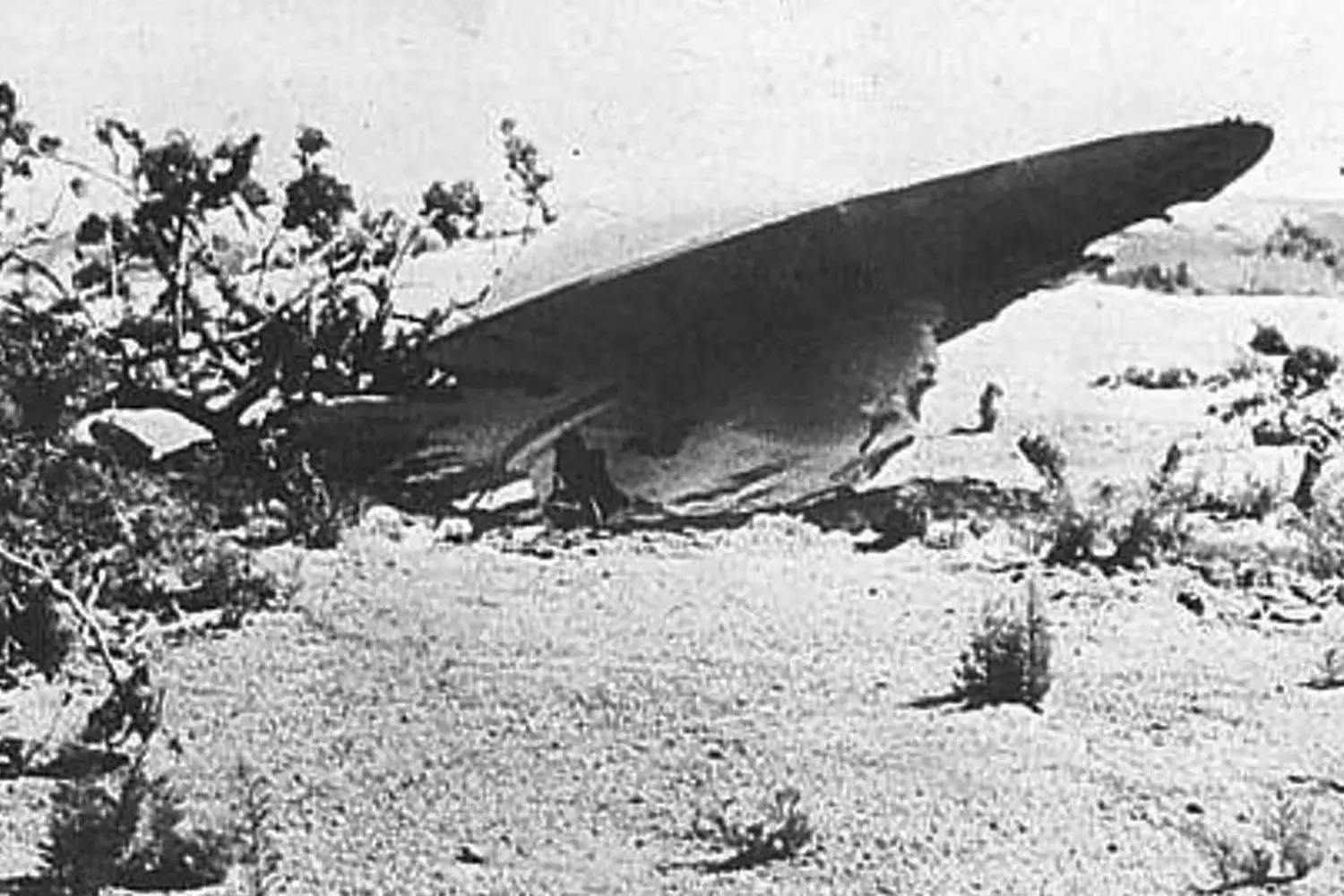 Mysterious Disc-Shaped Aircraft at Area 51 Hangar Vintage black and white photo of a UFO or experimental aircraft in a hangar, possibly at Area 51