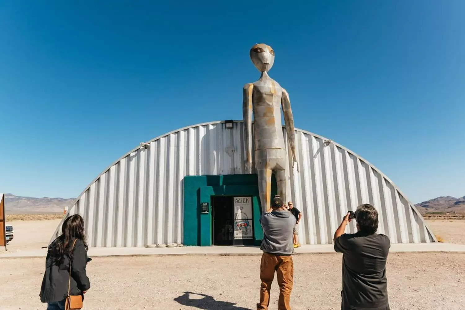 Area 51 Museum: Nevada's Quirkiest UFO & Military History Exhibit Exterior of the Area 51 Museum with UFO-themed displays and alien figurines visible through windows