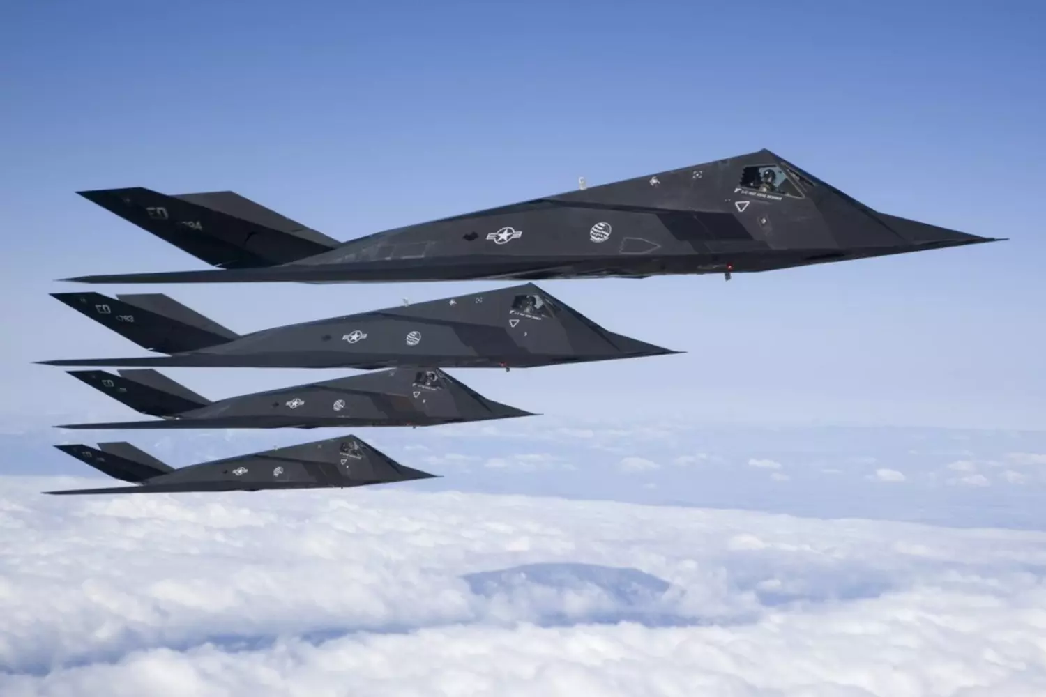 Lockheed F-117 Nighthawk — Secret Stealth Jet Tested at Area 51 Lockheed F-117 Nighthawk stealth fighter jet flying over desert area, possibly near Area 51