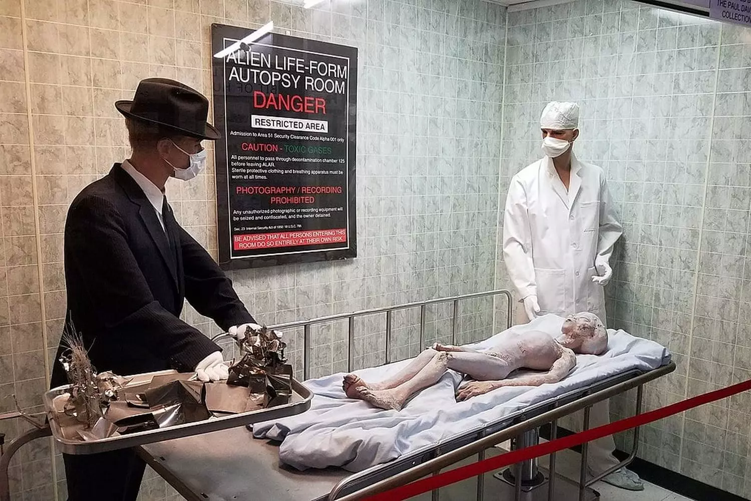 Area 51 Alien Autopsy Exhibit: Controversial Museum Diorama of Secret Experiments Museum exhibit diorama depicting an alien autopsy scene at Area 51, featuring realistic-looking mannequins of gray aliens on medical tables with scientists in hazmat suits