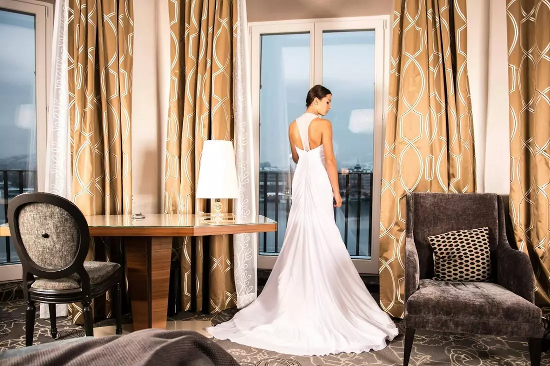 Невеста позирует для фото в номере роскошного отеля Невеста позирует для фото в номере отеля